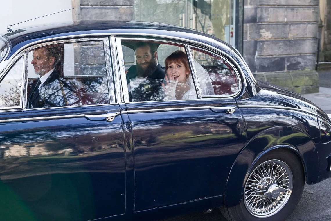 newlyweds depart in classic Jaguar car