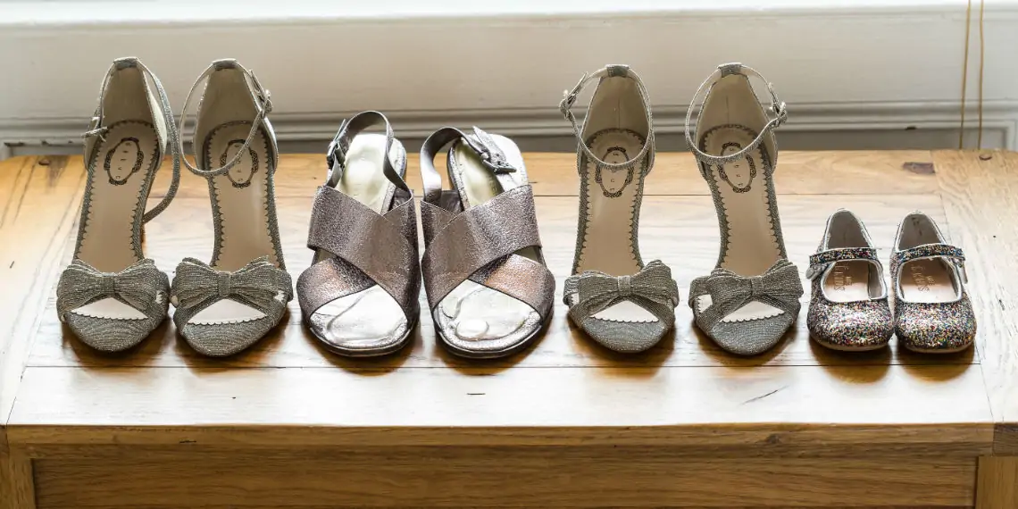 Four pairs of silver shoes lined up in a row