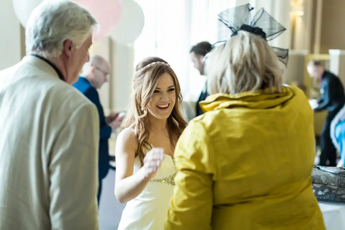 Candid photo of bride smiling at guest during drinks reception