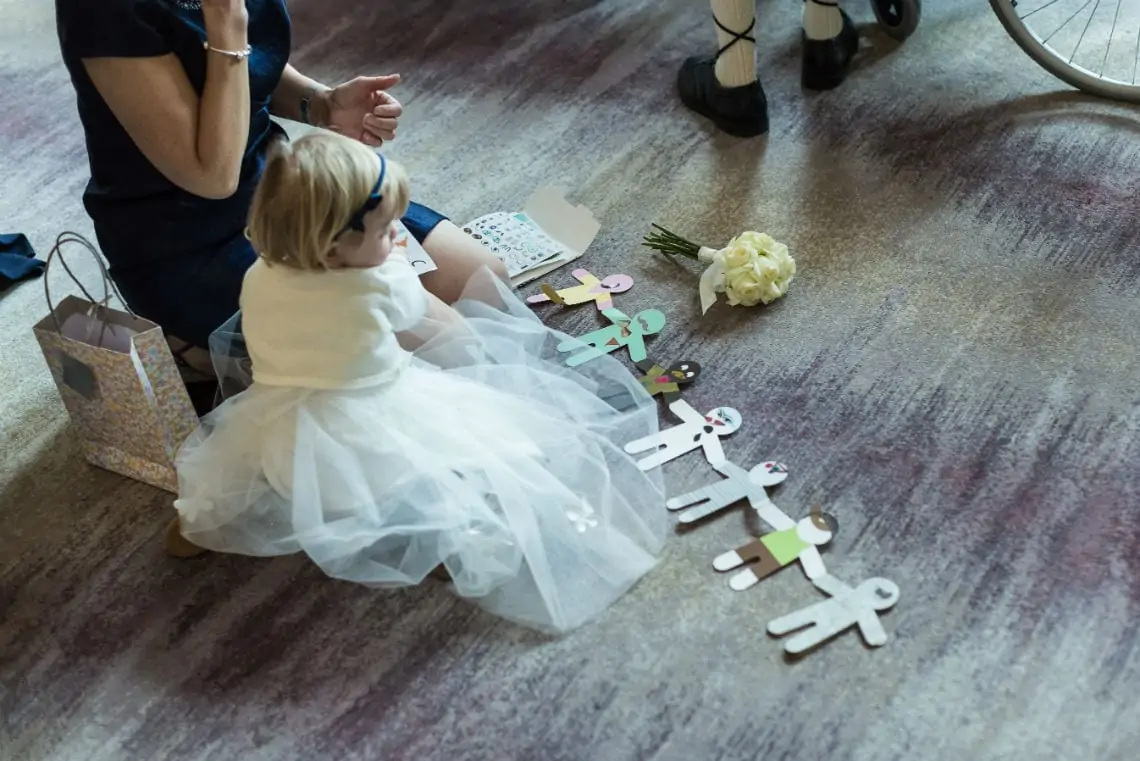 Little girl sitting on the floor playing with paper dolls