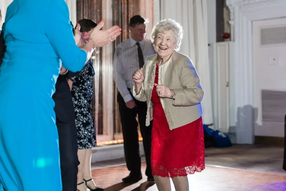 Elderly lady in red dress dancing and smiling