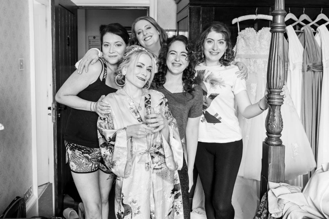 posed black and white photo of bride and her four bridesmaids in bedroom suite of castle