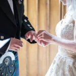 photo of bride placing ring on groom's finger