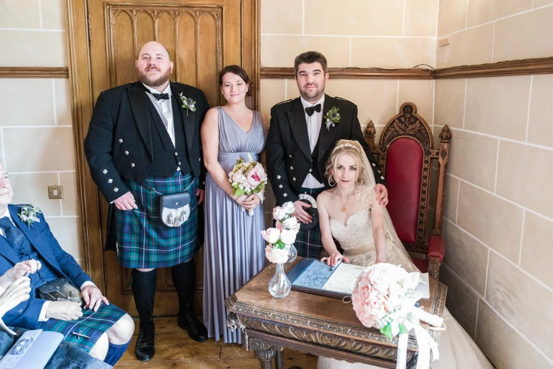 photo of bride and groom with bridesmaid and bestman as they sign marriage schedule