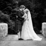 newlyweds kissing on the stone bridge