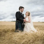 Wedding at Dalhousie Castle photo of newlyweds in field of barley