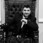 Wedding at Dalhousie Castle posed photo of groom sitting on chair