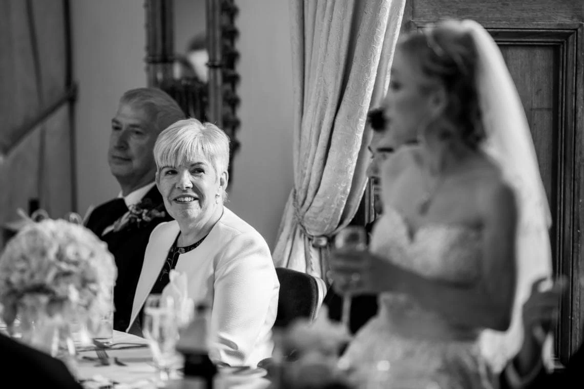 Mother of the groom watching bride during speech