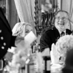 father of the bride smiling during speeches at wedding reception