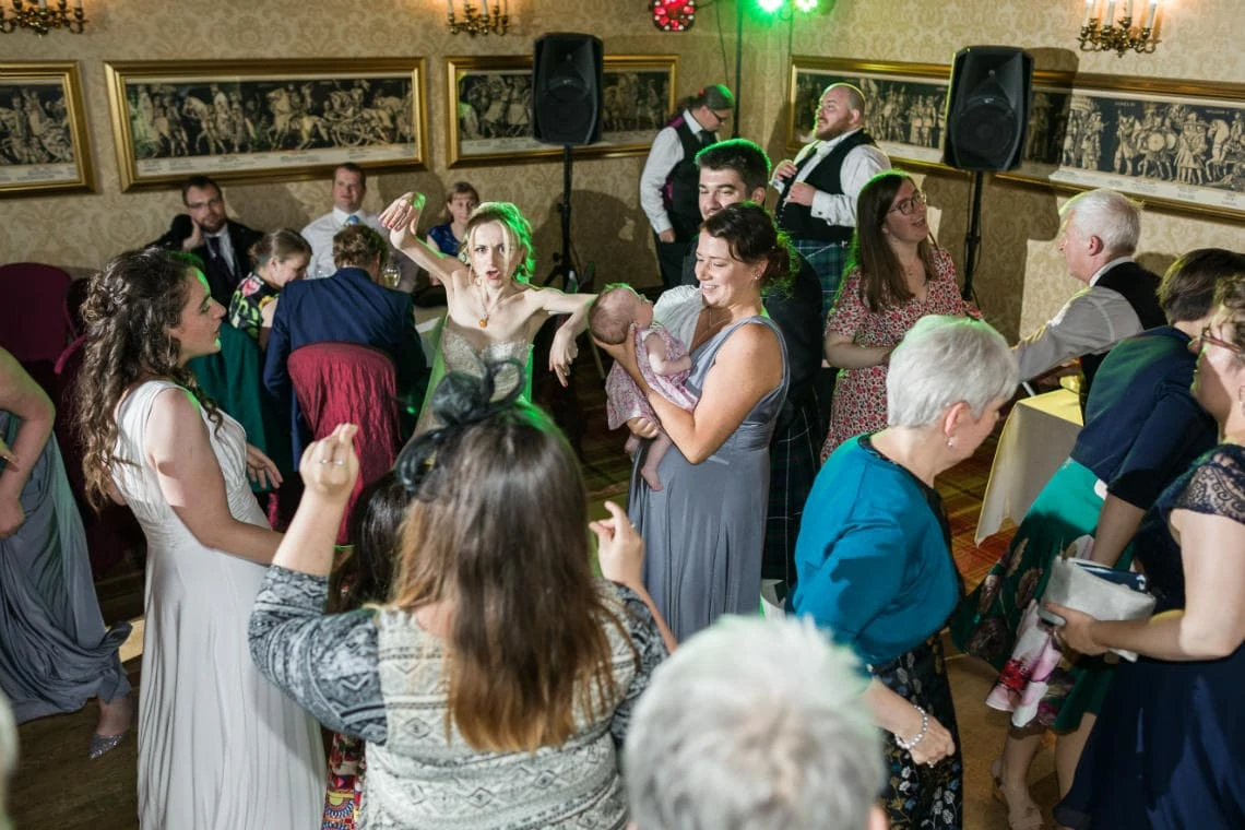 bride and guests dancing at evening reception