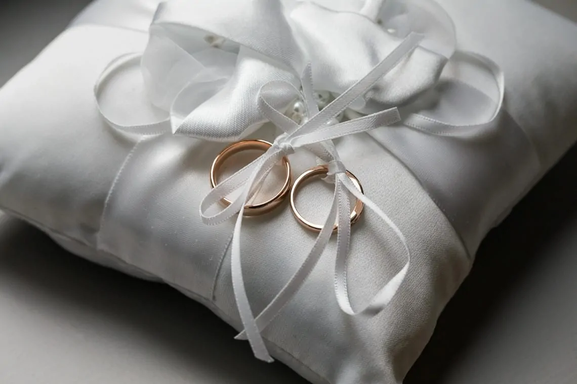 wedding rings tied to a padded cushion