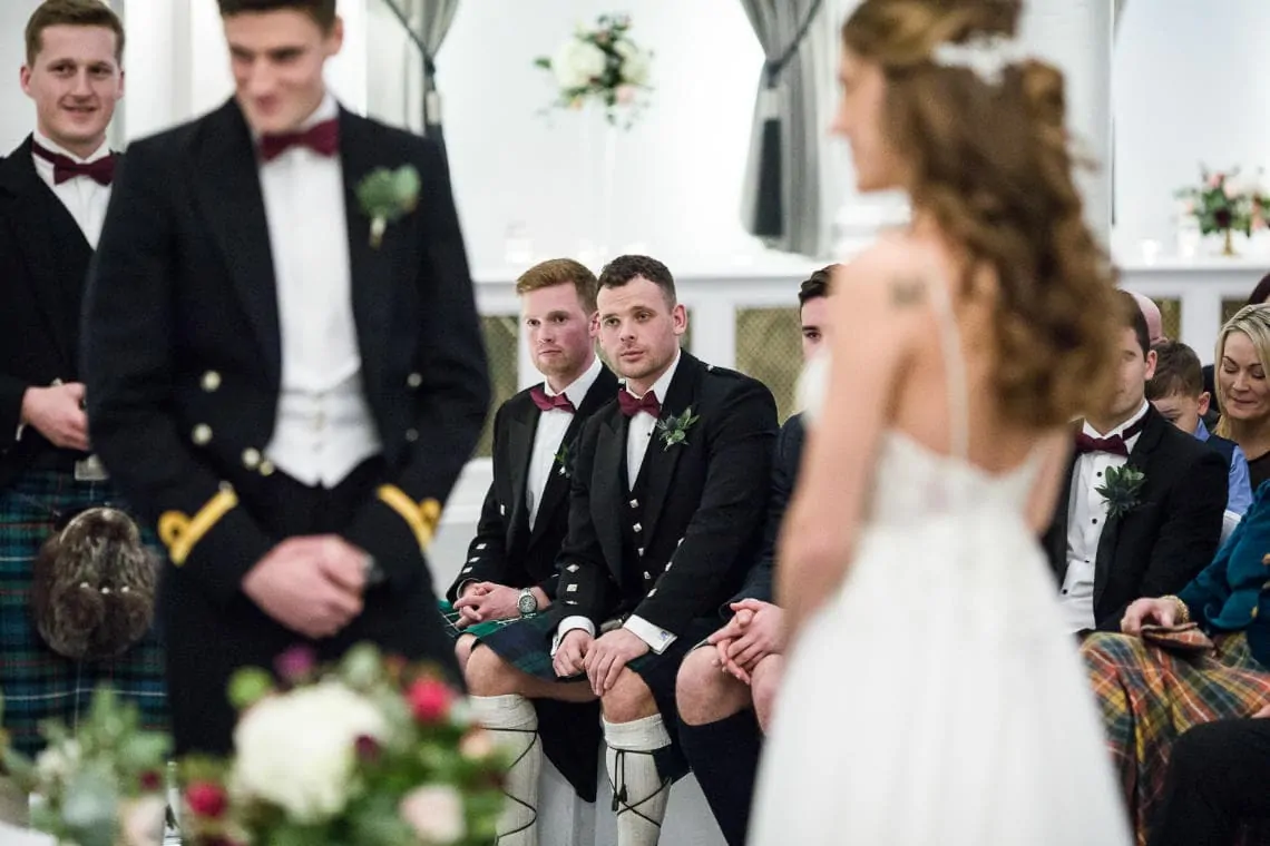 groomsmen watching the marriage ceremony in the King's Hall