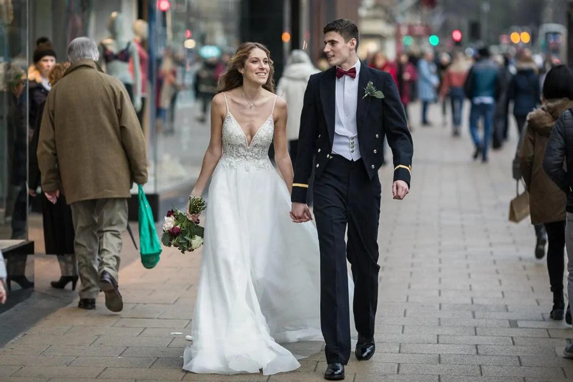 newlyweds holding hands as they walk along Princes Street