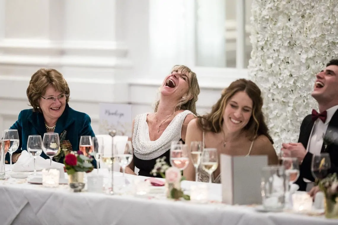 bride and her mother laughing during the best man's speech