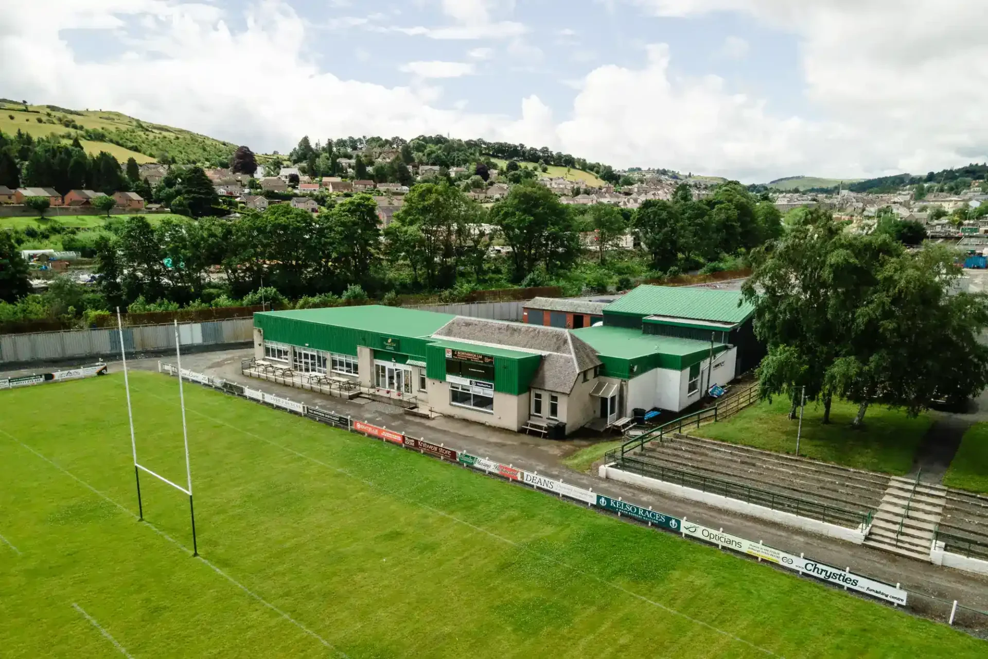 Drone photo of a sports pitch with a building and a goalpost at Hawick Rugby Football Club.