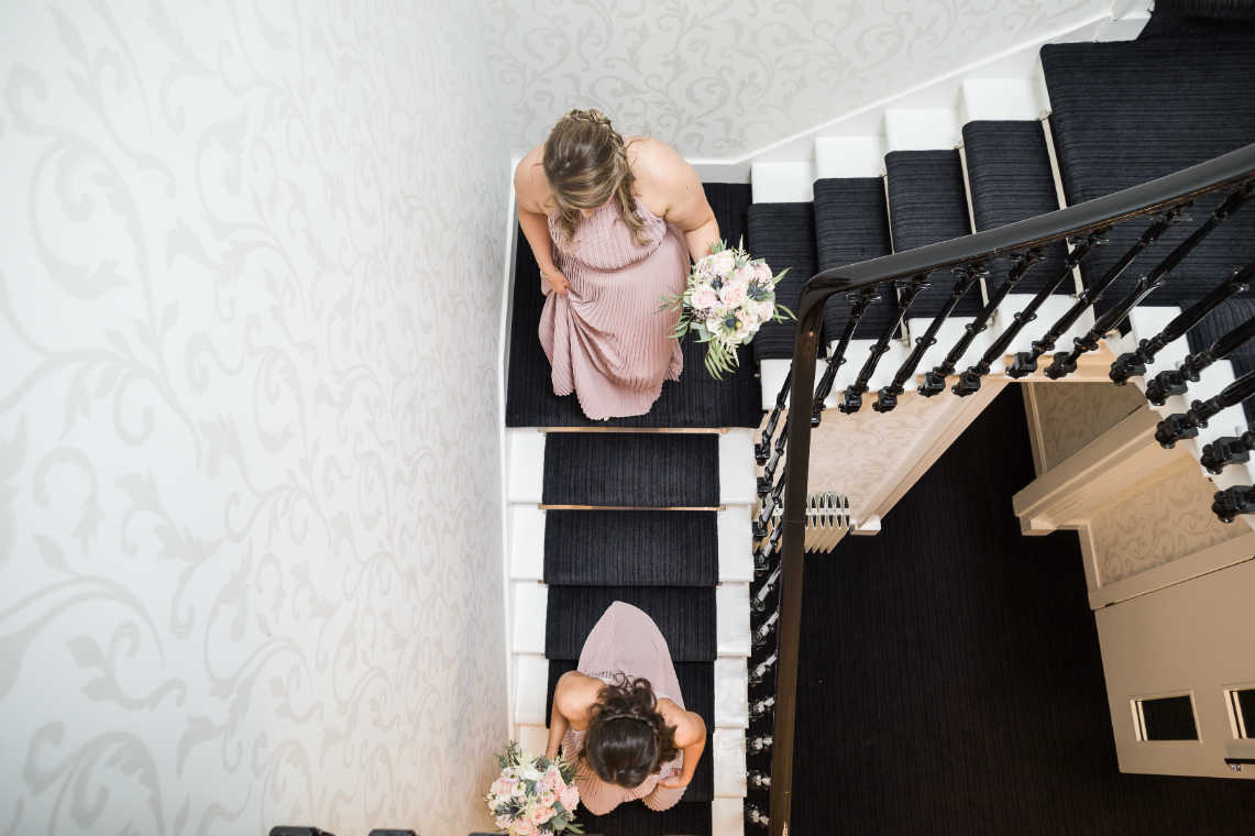 bridesmaids walk down the staircase