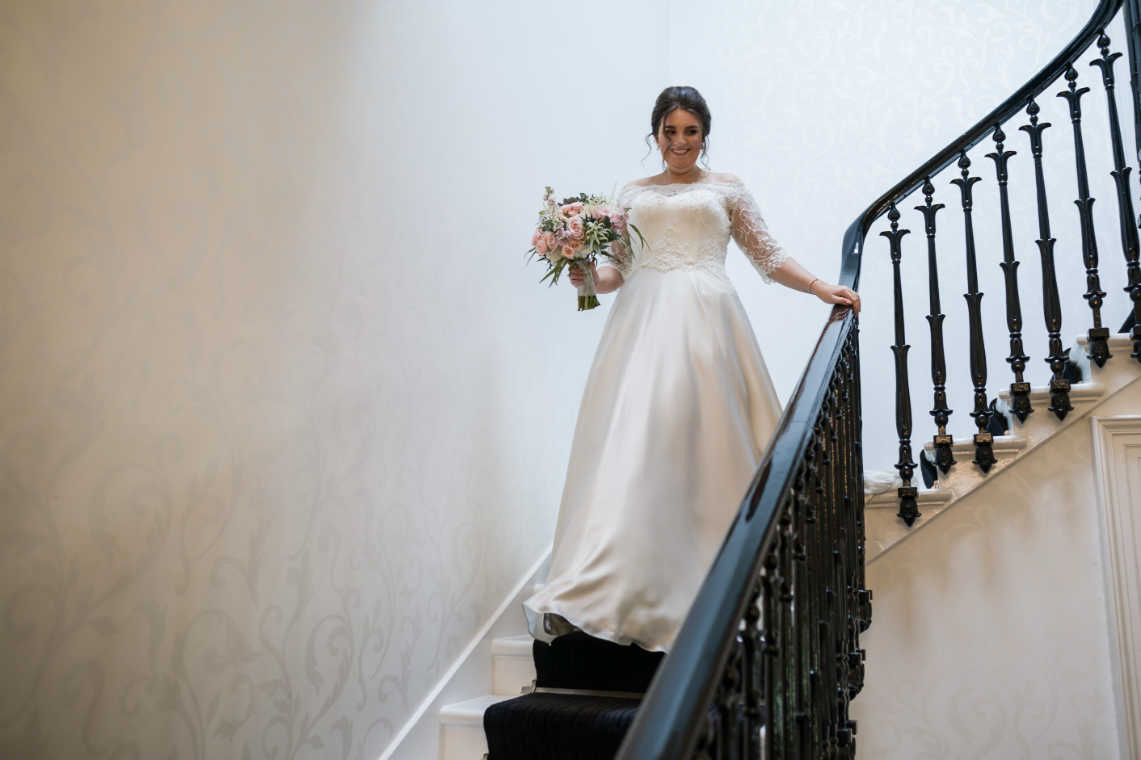 bride walks down the staircase