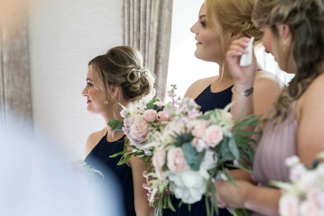 bridesmaids watch father and bride walk up the aisle during wedding processional