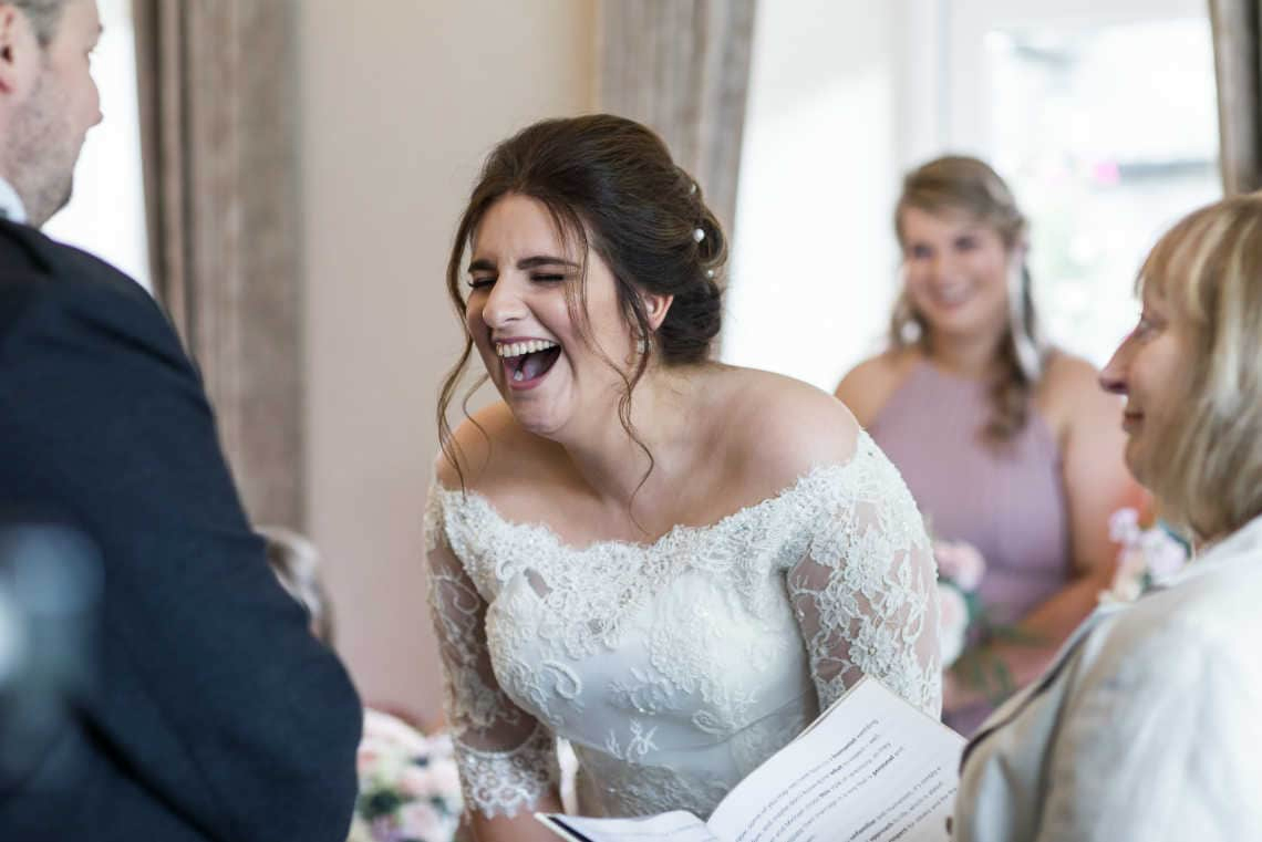 bride laughs during ceremony