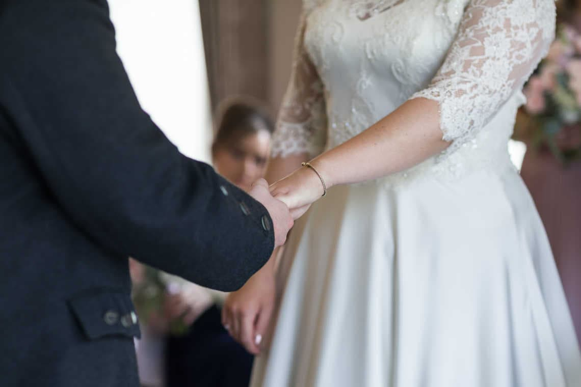 couple holding hands during the wedding ceremony