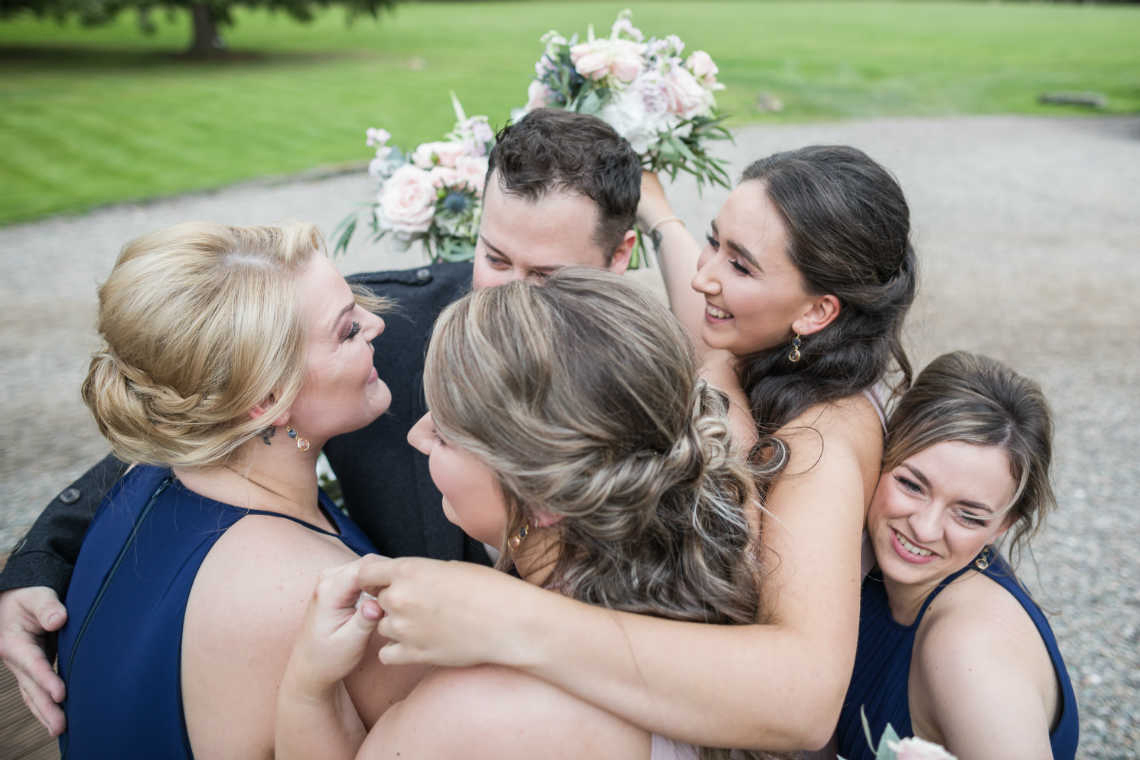 bridesmaids group hug newly-wed congratulations