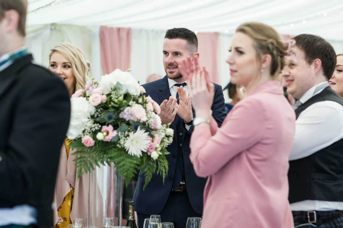 guests applauding newly-weds