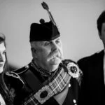 Pipe Major Iain Grant poses for a photo with guests