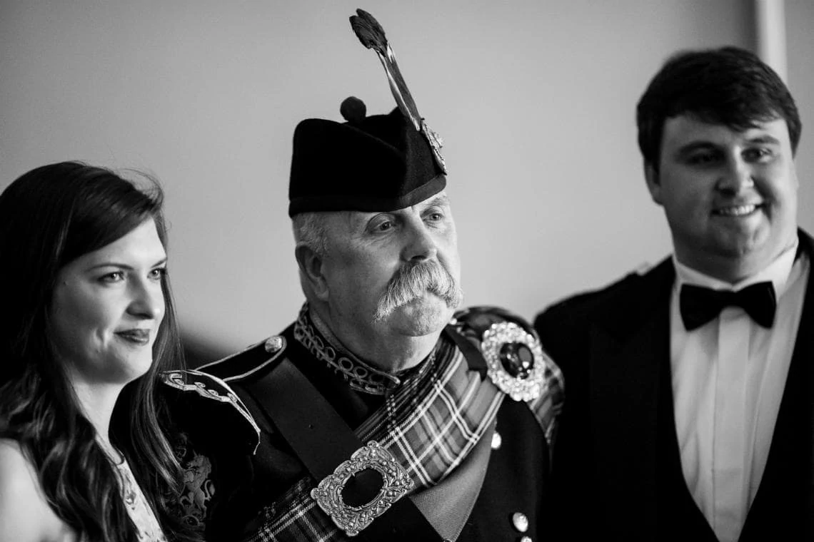 Pipe Major Iain Grant poses for a photo with guests